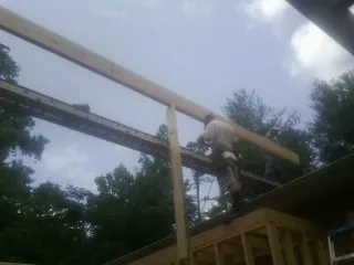 Carpenter setting a ridge beam over a new addition frame — Ice Dam Removal by Roofing Brothers in South Burlington