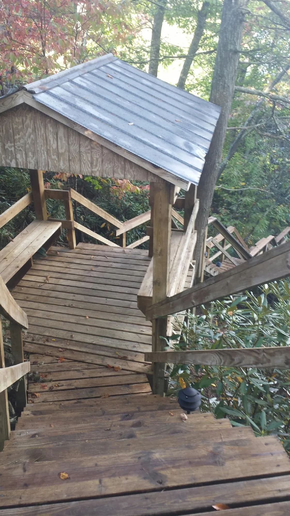 Metal roofed shelter over wooden steps on a wooded walkway in South Burlington