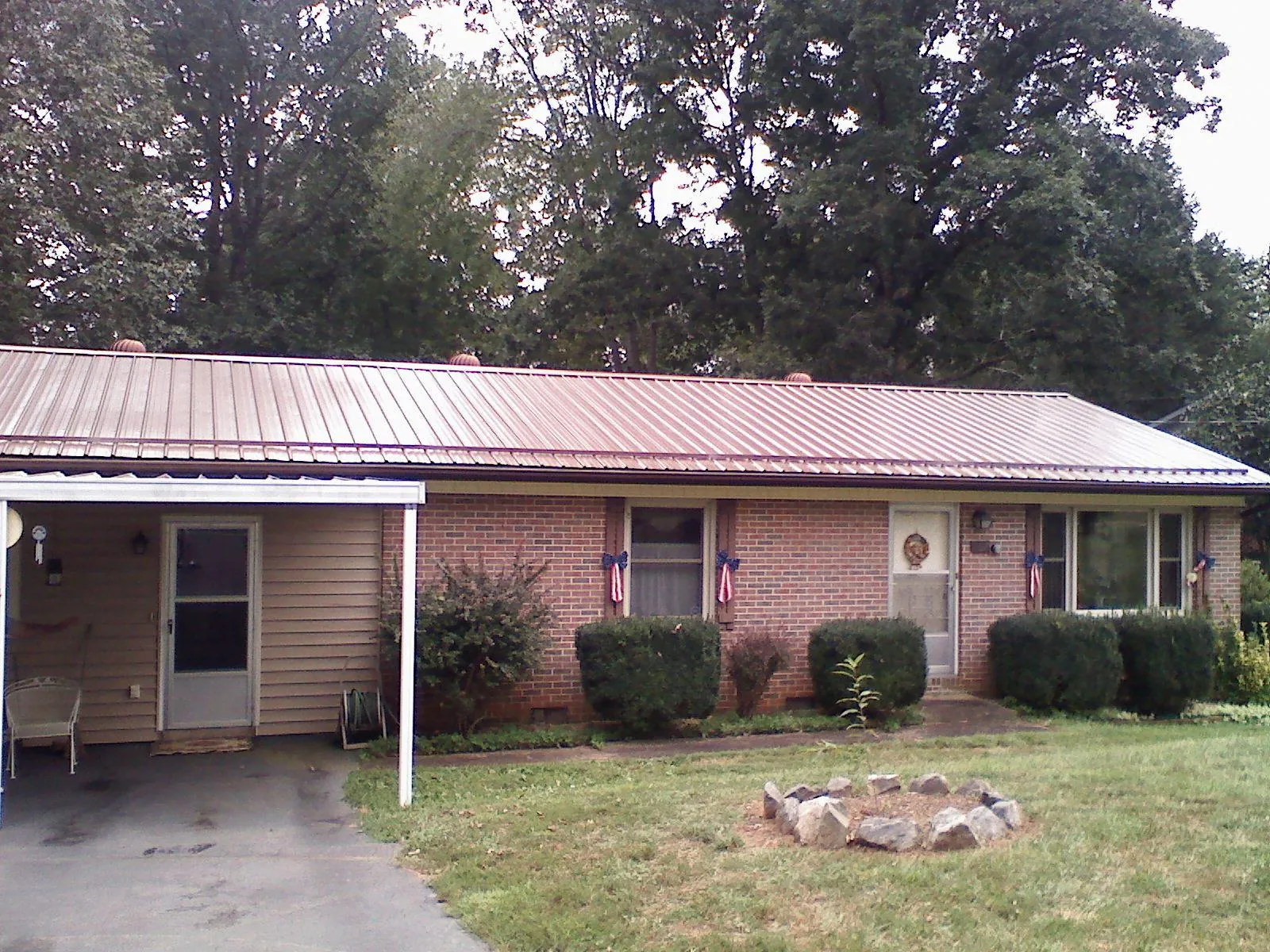 Bronze metal roof and carport on a brick ranch home — Roof Repair work by our crew in South Burlington